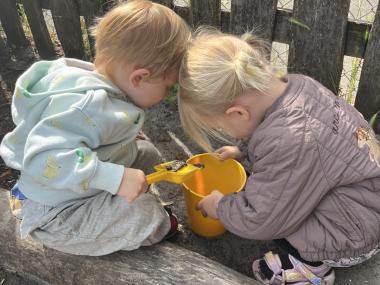 To børn der kigger i en spand