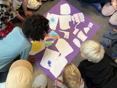 børn der læner sig ind og kigge på plakat