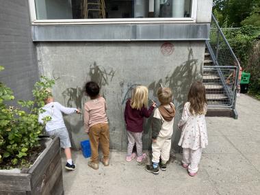 Børn der maler med vand på væggen 